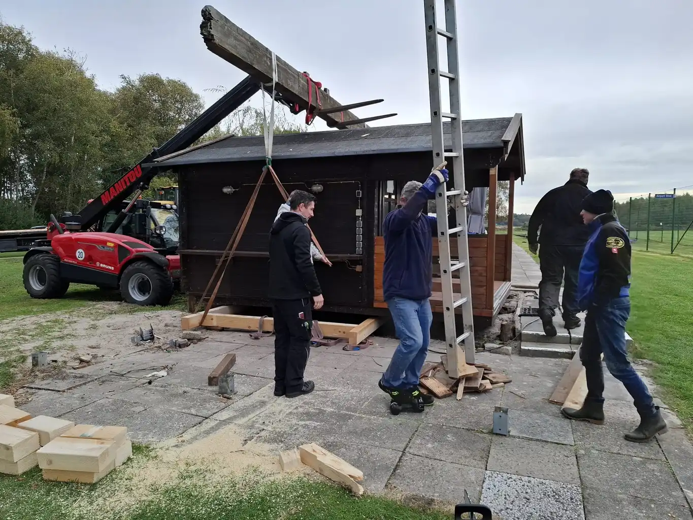 Mit vereinten Kräften und schweren Maschinen wird die Hütte verladen.